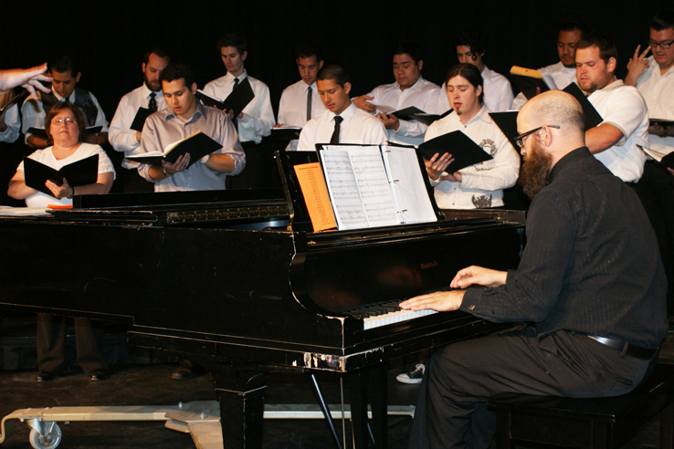A group of students singing and playing piano.